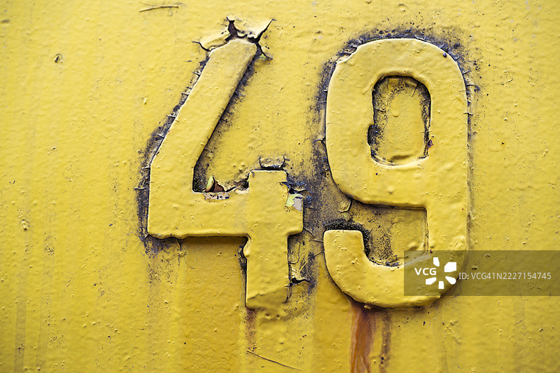 生锈的黄色金属表面上涂有数字四十九图片素材