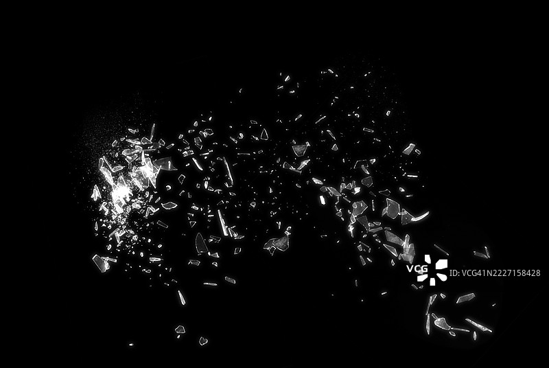 黑色背景上的破碎玻璃展示了碎玻璃的抽象纹理，细节丰富。该图像非常适合用作背景、纹理或抽象艺术项目。图片素材