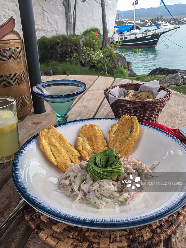 海边的海鲜酸橘汁腌鱼，配有炸绿香蕉片和鳄梨图片素材