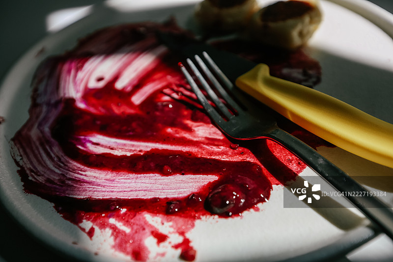 早餐结束。沾有覆盆子果酱的脏盘子和餐具图片素材