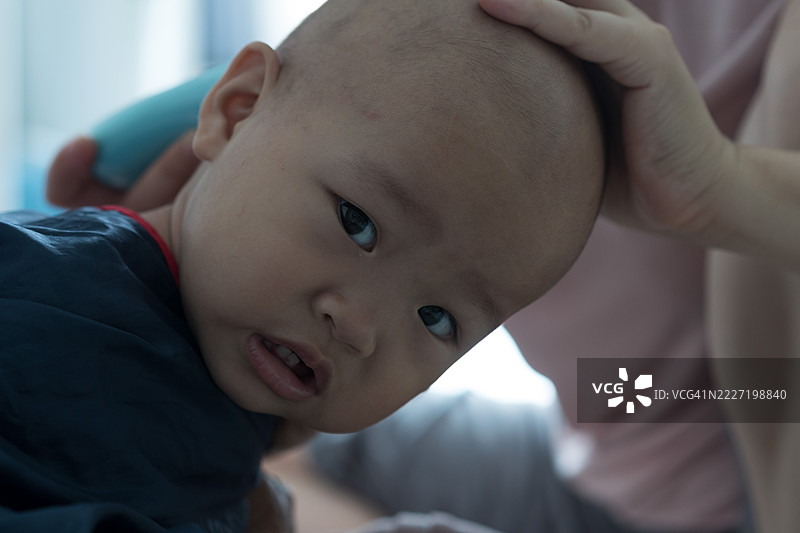 一岁大的亚洲女孩正在理发；亚洲家庭生活方式图片素材