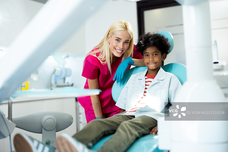 年轻男孩在现代诊所看牙医时微笑图片素材