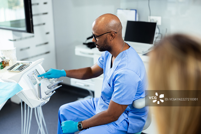 牙医在现代诊所准备牙科手术设备图片素材