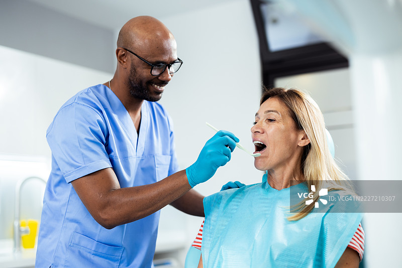 牙医为女性患者进行常规检查图片素材