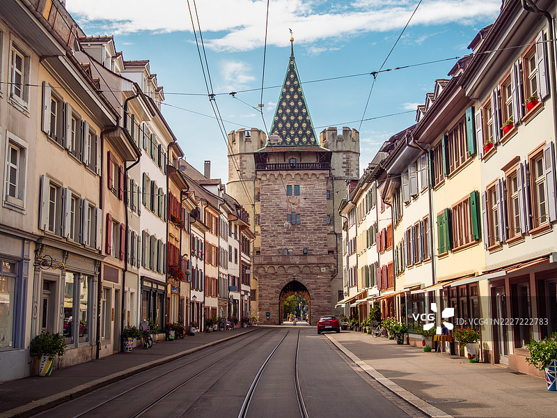 街道景观，五彩斑斓的建筑、 tramway 轨道，以及对斯普伦托尔（Spalentor，圣保罗之门）的视角，这是一座被列为历史遗迹的中世纪城门，位于瑞士巴塞尔 - 巴塞尔城市。图片素材