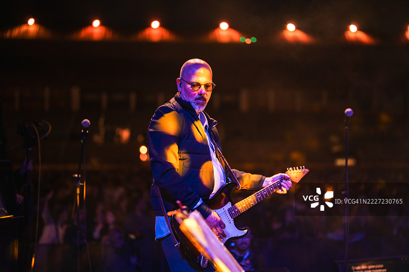 摇滚乐队在舞台上现场表演，灯光绚丽多彩图片素材