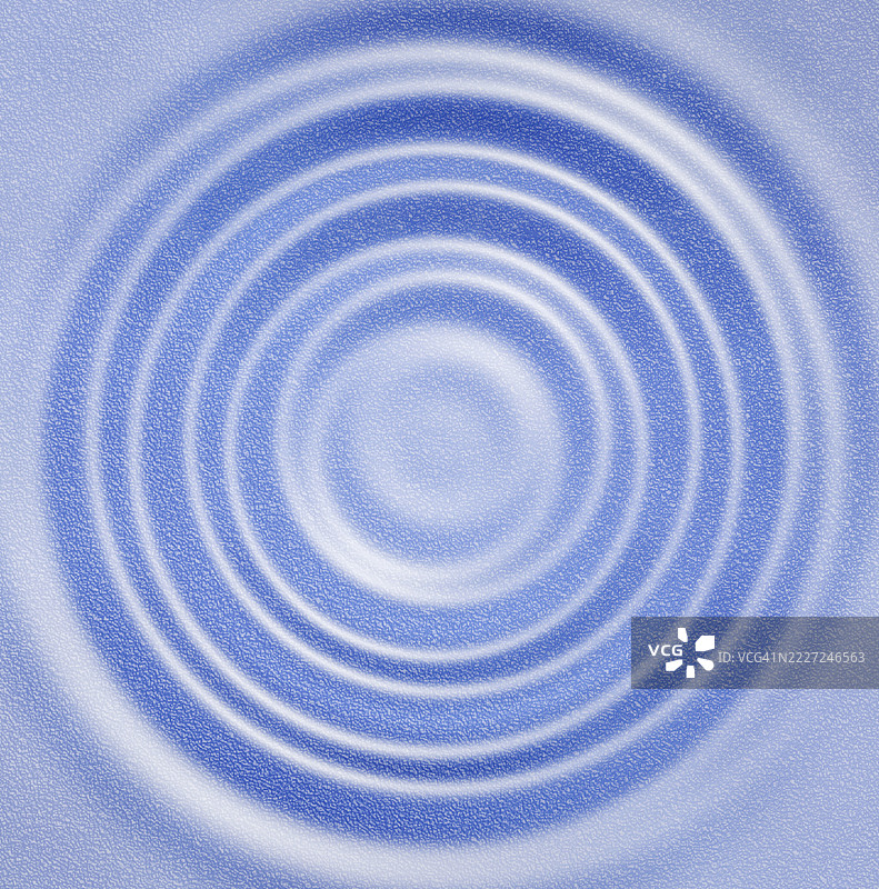 小波浪在蓝色表面上以同心圆的方式移动。图片素材