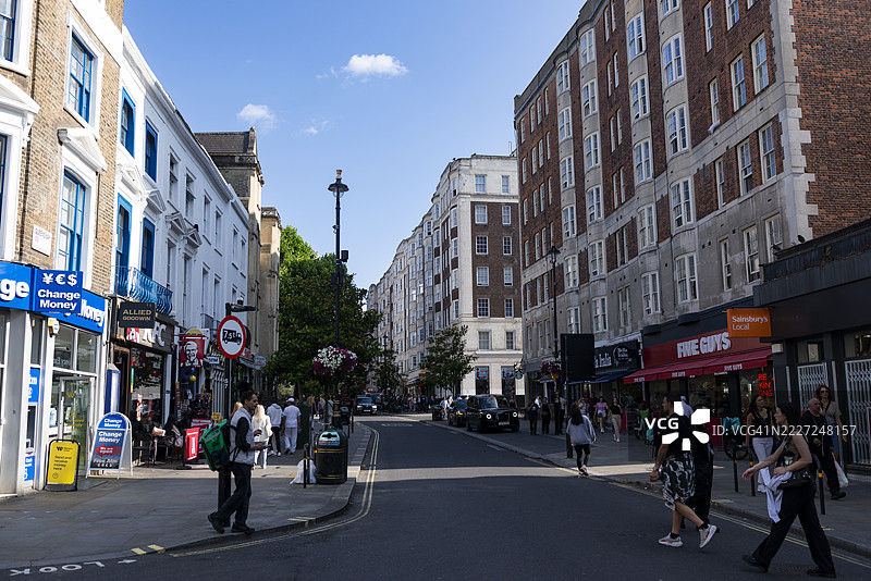 贝斯沃特车站周围的典型街景展示了混合用途建筑、城市活动以及便利的交通和设施。伦敦，英国。图片素材