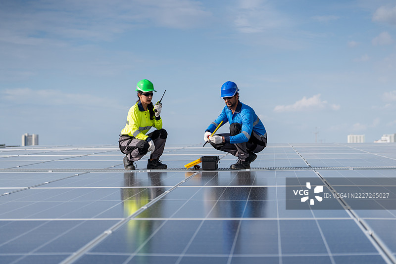 服务工程师正在检查屋顶太阳能电池板的维护情况，并检查是否有任何损坏的部件。技术人员还参与太阳能电池板的安装，推广清洁能源的使用。图片素材