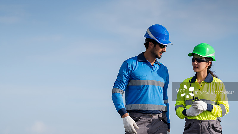 服务工程师正在检查屋顶太阳能电池板的维护情况，并检查是否有任何损坏的部件。技术人员还参与太阳能电池板的安装，推广清洁能源的使用。图片素材