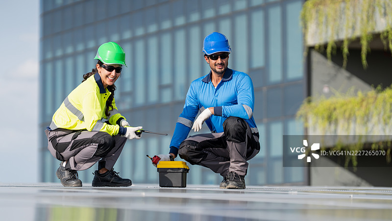 服务工程师正在检查屋顶太阳能电池板的维护情况，并检查是否有任何损坏的部件。技术人员还参与太阳能电池板的安装，推广清洁能源的使用。图片素材