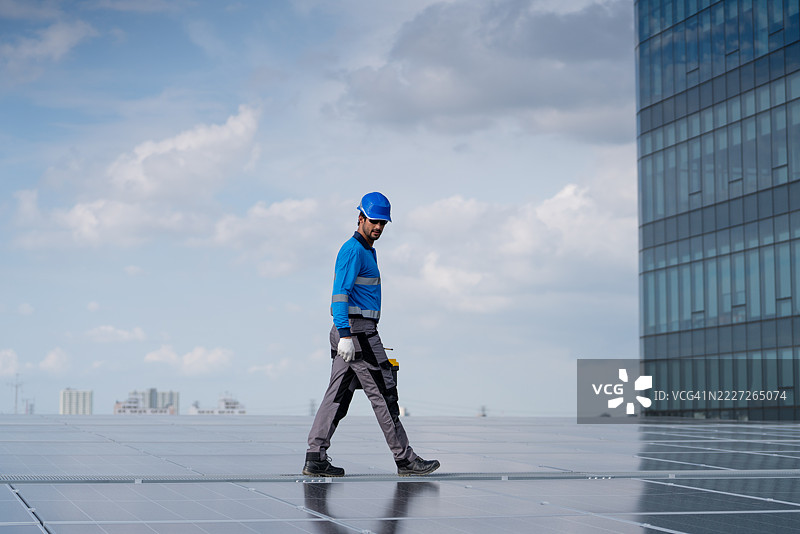 服务工程师正在检查屋顶太阳能电池板的维护情况，并检查是否有损坏的部件。技术人员还参与太阳能电池板的安装，推广清洁能源的使用。图片素材