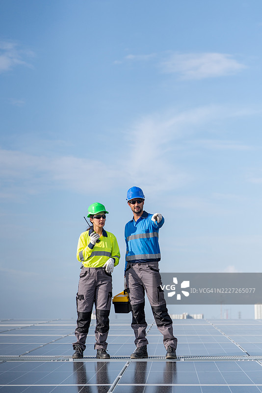 服务工程师正在检查屋顶太阳能电池板的维护情况，并检查是否有损坏的部件。技术人员还参与太阳能电池板的安装，推广清洁能源的使用。图片素材