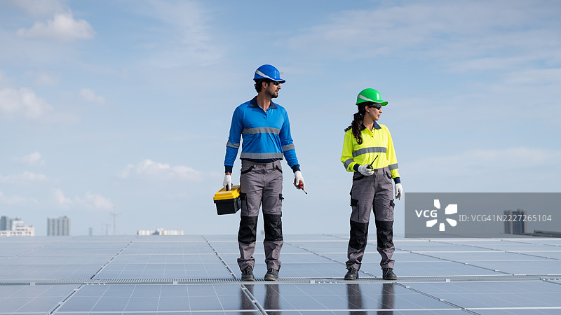 服务工程师正在检查屋顶太阳能电池板的维护情况，并检查是否有损坏的部件。技术人员还参与太阳能电池板的安装，推广清洁能源的使用。图片素材