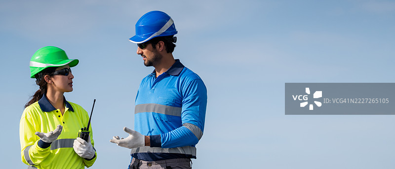 服务工程师正在检查屋顶太阳能电池板的维护情况，并检查是否有损坏的部件。技术人员还参与太阳能电池板的安装，推广清洁能源的使用。图片素材