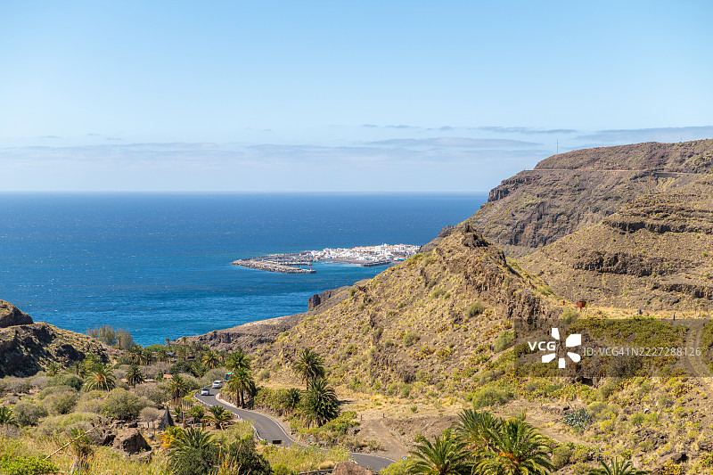 风景如画的海岸公路蜿蜒穿过火山丘陵，俯瞰西班牙加那利群岛的阿加特。图片素材