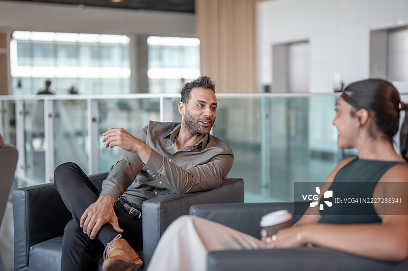 两位专业人士在现代工作环境中交谈图片素材