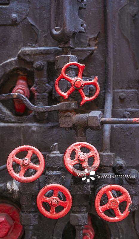 老蒸汽火车锅炉的红色阀门和控制装置图片素材