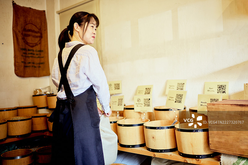 店主正在为一家按重量出售咖啡豆的咖啡豆店开业做准备。图片素材