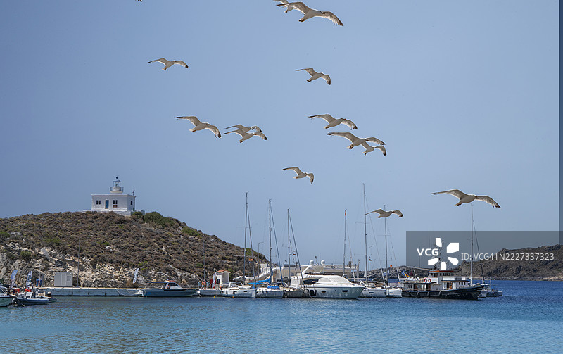 希腊岛屿上的灯塔和船只。图片素材