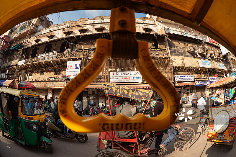 从三轮车内框住的旧德里街景图片素材