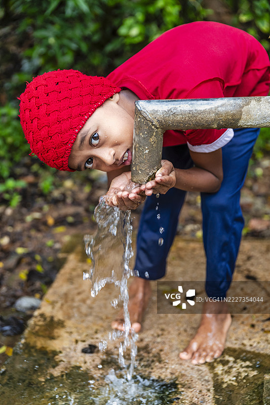 斯里兰卡小男孩在喝水，锡兰图片素材