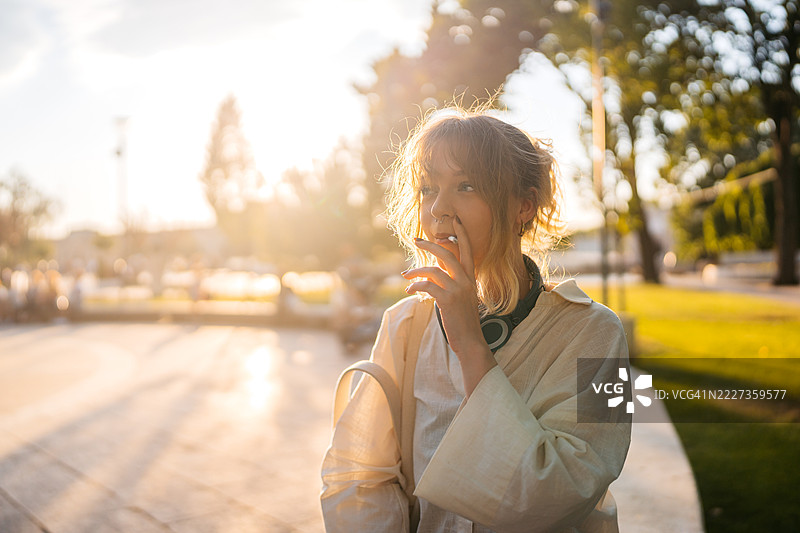 年轻女性在公共公园吸烟图片素材