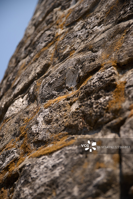 低角度特写展示了一座古老的砖砌瞭望塔，背景是晴朗的蓝天。图片素材