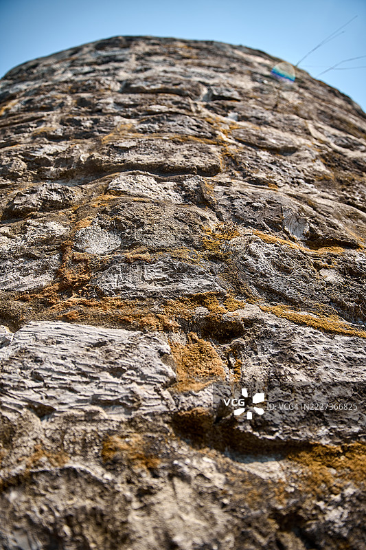 低角度特写展示了一座古老的砖砌瞭望塔，背景是晴朗的蓝天。图片素材