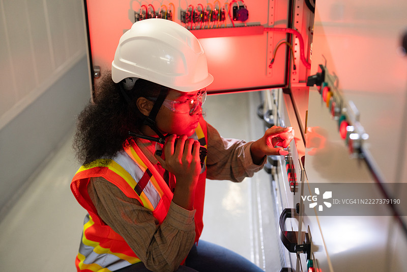 女性工程师在应急灯下进行故障排除图片素材