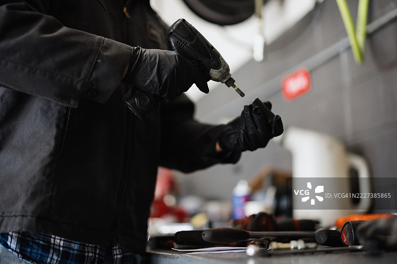 机械师在车间用电钻拧紧螺丝图片素材
