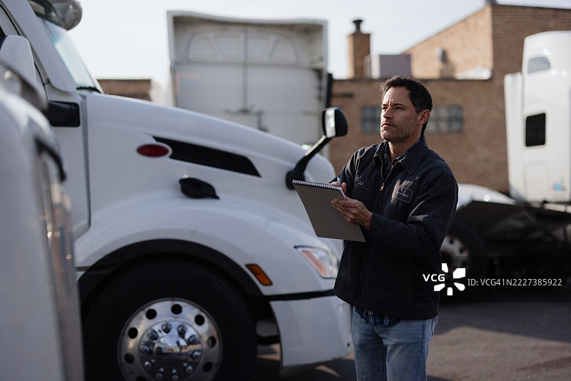 卡车司机在开始新的送货之前检查他的车辆图片素材