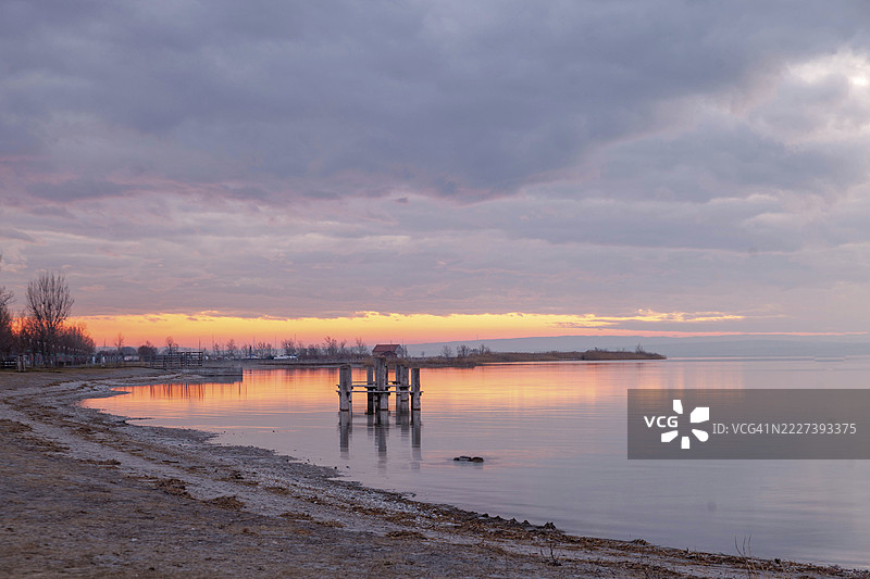 日落时分，波德斯多夫湖（Neusiedl）宁静的海滩与码头，柔和的粉彩色调，奥地利布尔根兰州。图片素材