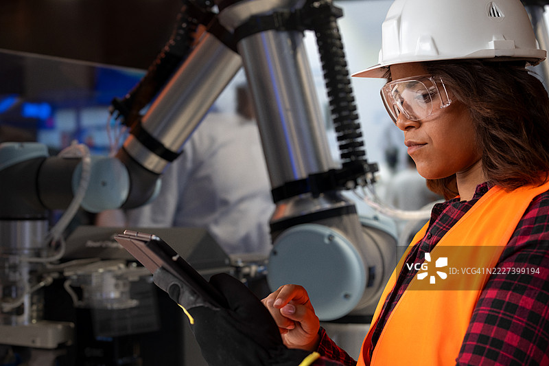 技术人员使用平板电脑控制工业机器人图片素材