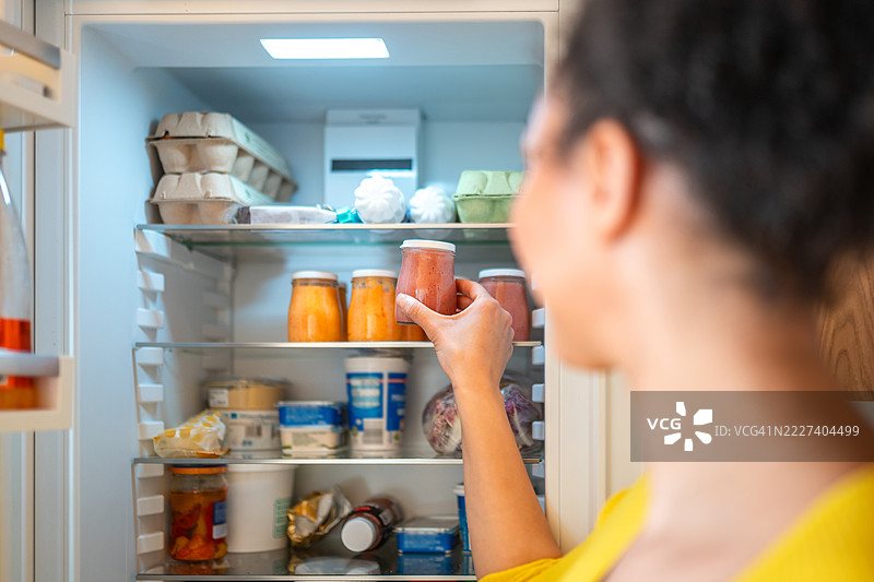 多种族女性在整齐的冰箱中储存自制婴儿食品图片素材