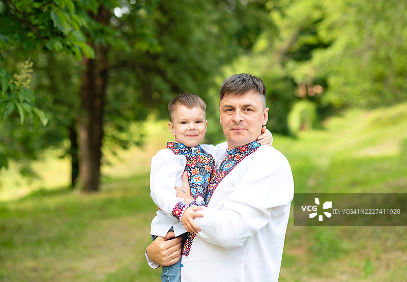 身穿民族服饰vyshyvanka的乌克兰家庭。父亲和女儿在乌克兰独立日的公园里。图片素材