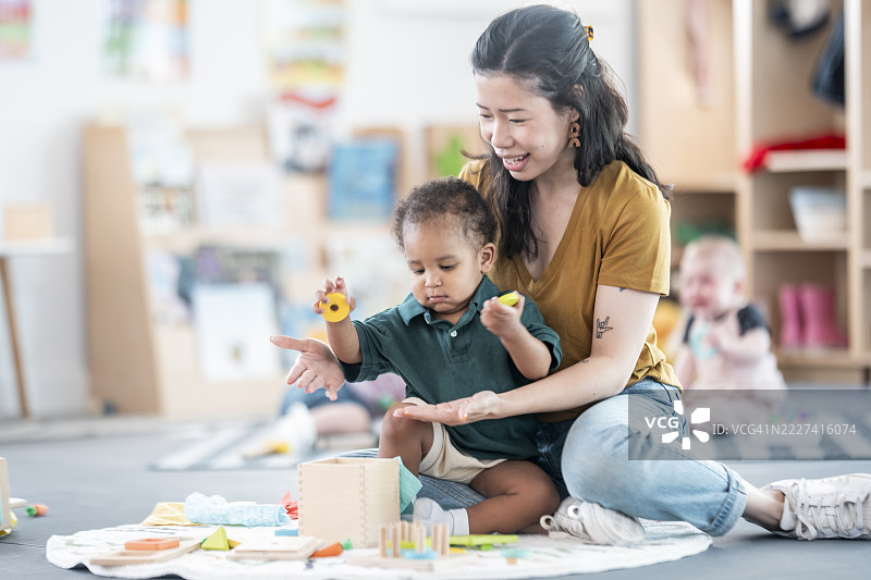 教师在幼儿园教室中协助幼儿进行学习活动图片素材