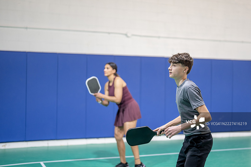 两个人在室内球场上专注地打皮克球图片素材