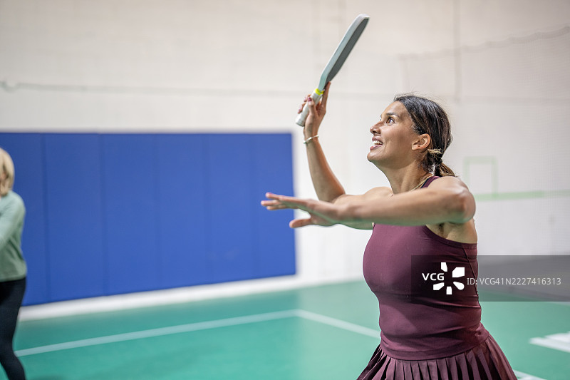兴奋表情的女性在室内打羽毛球图片素材