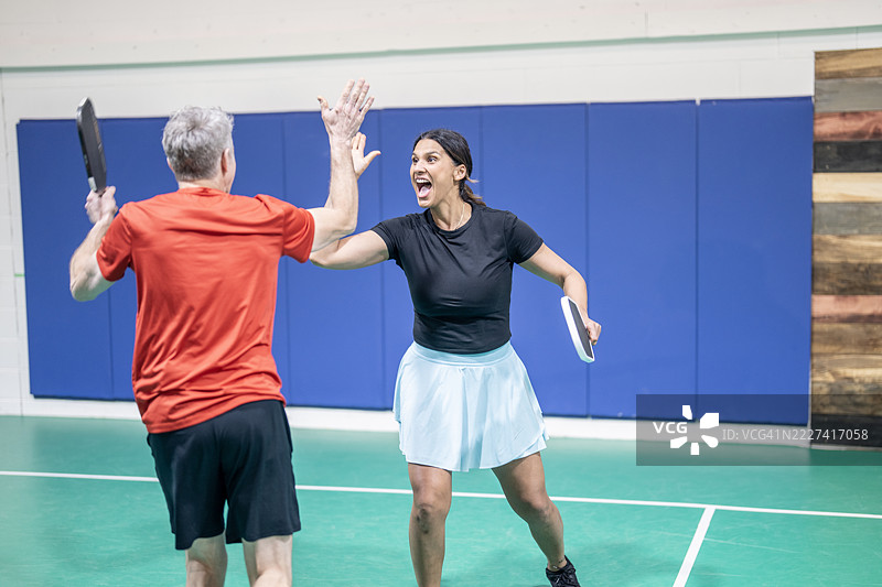 兴奋的球员们在室内庆祝成功的皮克球比赛图片素材