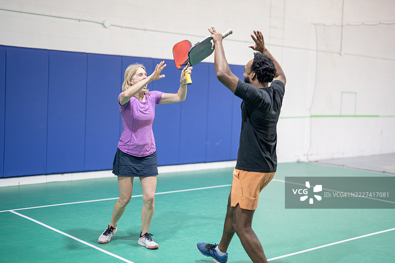 两位成年人参与有趣的室内划桨运动活动图片素材