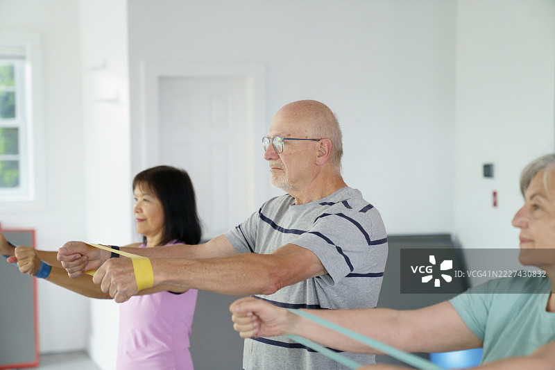 一群老年人参加阻力带锻炼课程图片素材