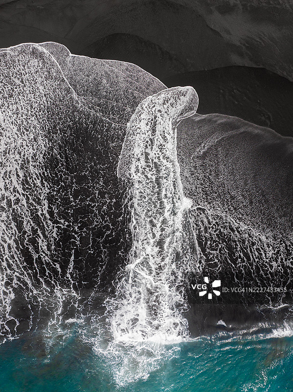 从印度洋延伸到印度尼西亚巴厘岛克伦贡区火山海滩的长波的俯视图图片素材