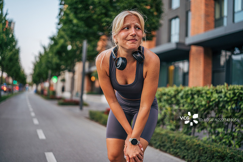 年轻的运动女性在城市跑步后感到膝盖疼痛图片素材