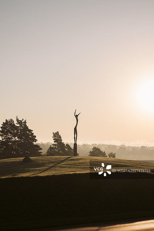日落时分，女人在田野上站立，背景是天空，阿利图斯，阿利图斯地区，立陶宛图片素材