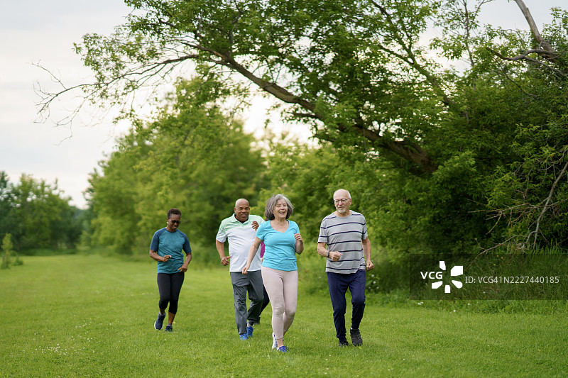 一群成年人在绿色公园环境中锻炼和慢跑图片素材