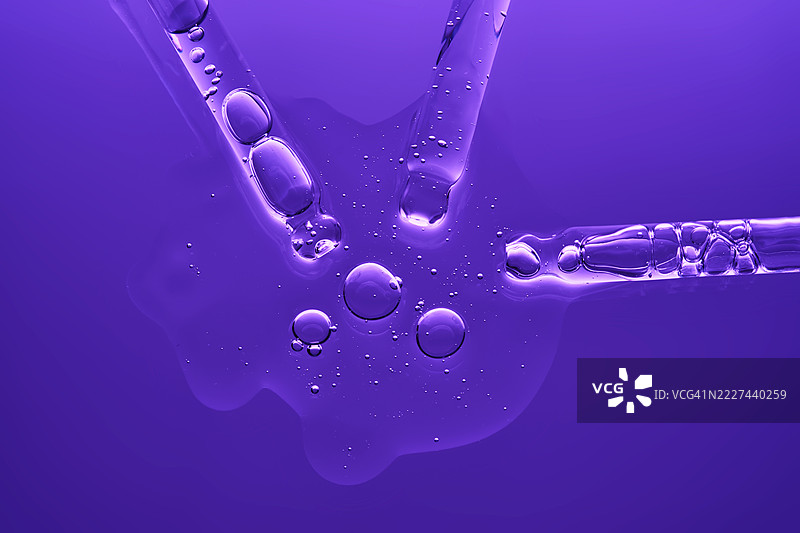 美丽的精华质地，带有气泡，背景为深紫色图片素材