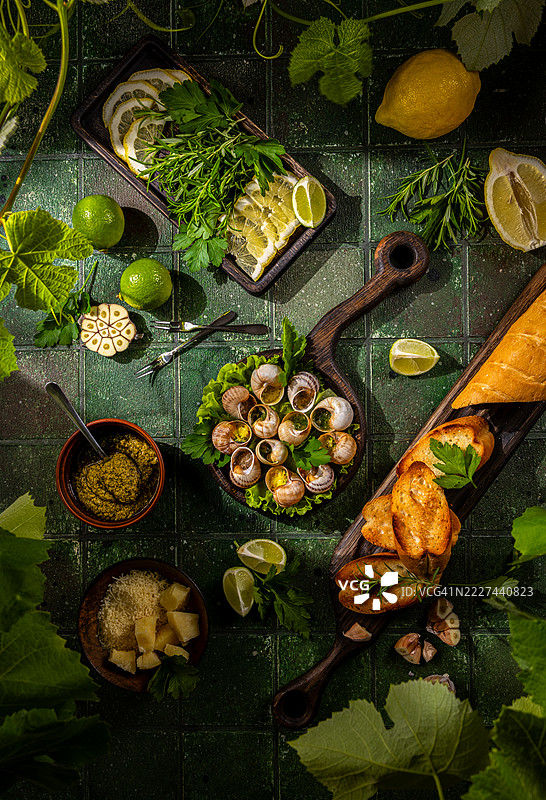 乌克兰的香蒜黄油、香草和面包丁的勃艮第蜗牛，摆放在绿色瓷砖上图片素材