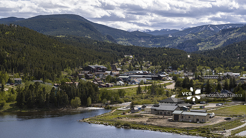 位于森林和湖泊之间的落基山小镇。科罗拉多州博尔德县的小社区，背景是白雪皑皑的山峰。图片素材