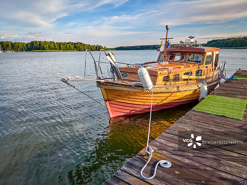 一艘美丽的木船停靠在宁静的湖面上图片素材